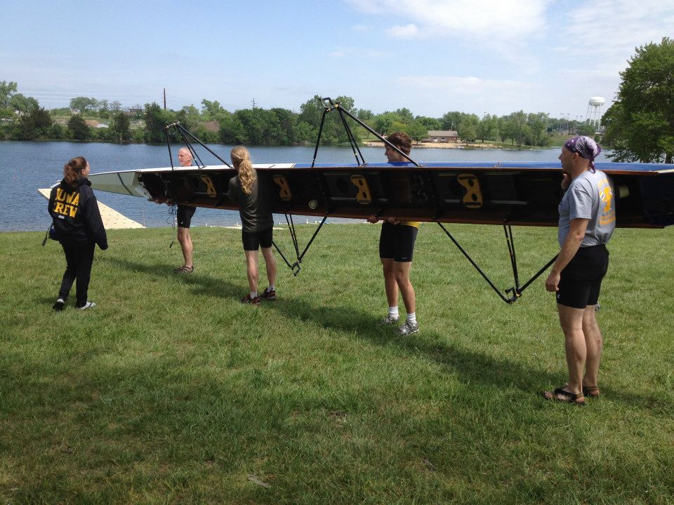 Four rowers and a cox waiting with a boat